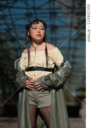 A beautiful Asian woman in shorts and a green leather coat comes out of the subway. A beautiful Asian woman in shorts and a green leather coat comes out of the subway. 110992508