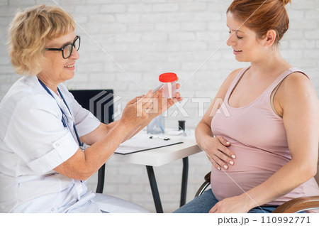 The doctor explains to a pregnant patient how to pass a urine test. The doctor explains to a pregnant patient how to pass a urine test. 110992771