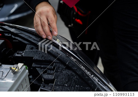The process of applying protective vinyl film to car headlights in detailing. The process of applying protective vinyl film to car headlights in detailing. 110993113