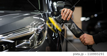 A master polishes the surface of a car body.  110993291