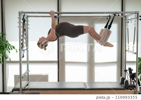 Pregnant woman doing pilates on a reformer.  110993355