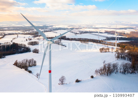 Winter meadow with wind turbines generating electricity. Green energy concept. Winter meadow with wind turbines generating electricity. Green energy concept. 110993407