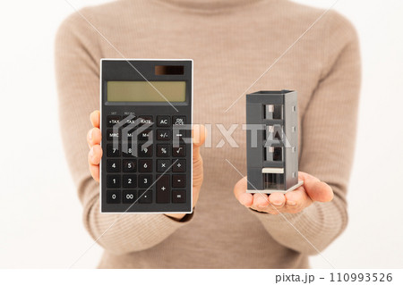 ビルの模型と電卓を持つミドル女性 110993526
