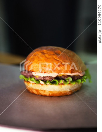 Fresh tasty burger on dark background. Soft focus. Vertical photo. High quality photo 110994370
