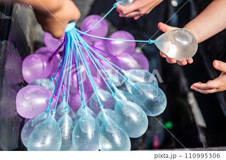Rapid filling self sealing water balloons being inflated with a hose. Rapid filling self sealing water balloons being inflated with a hose. 110995306
