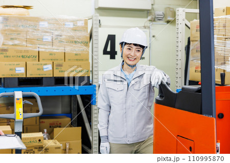 倉庫で働くヘルメットをかぶった女性 110995870