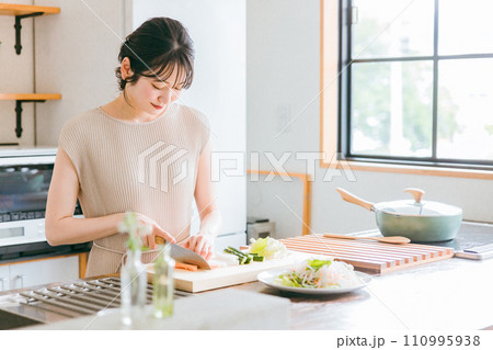 キッチンで料理・家事をする若い女性・妻・主婦(包丁・切る・野菜) キッチンで料理・家事をする若い女性・妻・主婦(包丁・切る・野菜) 110995938