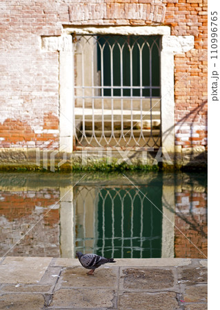 Italy. Close-ups of building facades in Venice. A look at the old scratched arch in the wall near the water in the canal. Italy. Close-ups of building facades in Venice. A look at the old scratched arch in the wall near the water in the canal. 110996765