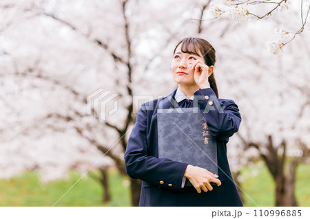 桜の下で涙を流す高校生・女子高生（卒業生・卒業式・卒業） 110996885