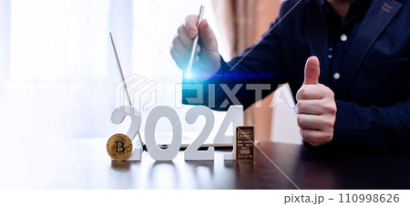 businessman buys gold and bitcoin in 2024 using digital technology and laptop computer. Finance and trade concept 2024. 110998626