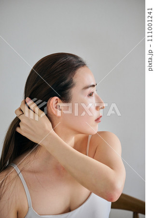 髪をかきわけるロングヘアの30代女性 111001241