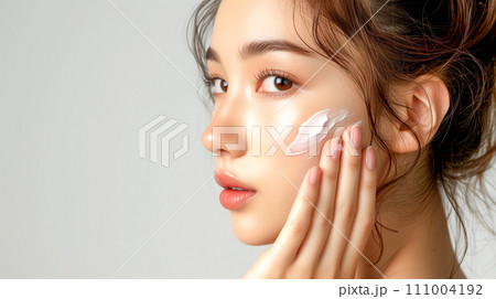 頬に白いクリームを付ける女性 111004192