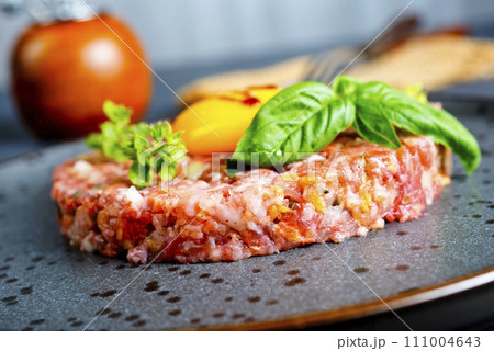 Top view of raw minced meat with liquid egg yolk for preparation of meatball placed on gray plate Top view of raw minced meat with liquid egg yolk for preparation of meatball placed on gray plate 111004643