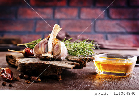 garlic rosemary and oil on wooden board garlic rosemary and oil on wooden board 111004840