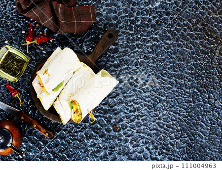 Salmon and cream cheese wraps. Rolls with smoked salmon, basil and rocket salad. Burrito on serving board Salmon and cream cheese wraps. Rolls with smoked salmon, basil and rocket salad. Burrito on serving board 111004963