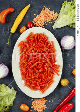 Raw orange spiral noodles. 111006556