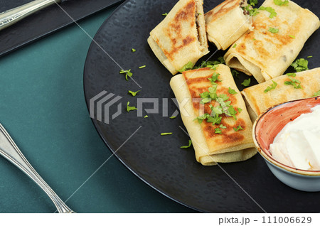 Thin pancakes with meat fillings. 111006629