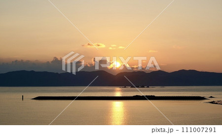 沖縄県座間味村阿嘉島から見た渡嘉敷島の日の出 沖縄県座間味村阿嘉島から見た渡嘉敷島の日の出 111007291