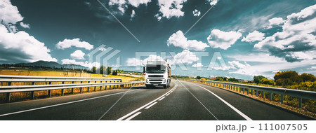 White Truck Or Traction Unit In Motion On Road, Freeway. Asphalt Motorway Highway Against Background Of Mountains Landscape. Business Transportation, Trucking Industry White Truck Or Traction Unit In Motion On Road, Freeway. Asphalt Motorway Highway Against Background Of Mountains Landscape. Business Transportation, Trucking Industry 111007505