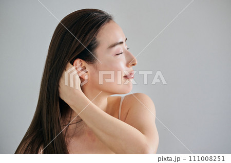 髪をかきわけるロングヘアの30代女性 髪をかきわけるロングヘアの30代女性 111008251