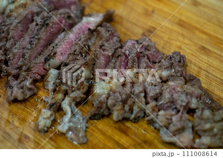 Medium rare sliced meat on wooden cutting board Medium rare sliced meat on wooden cutting board 111008614