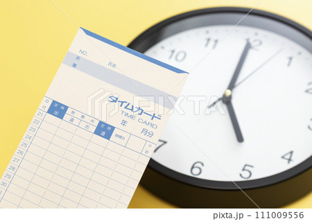黄色背景に掛け時計とタイムカード 111009556