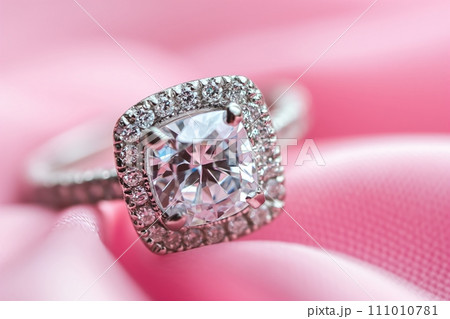 Diamond engagement ring on a pink silk background. Luxury female jewelry close-up 111010781