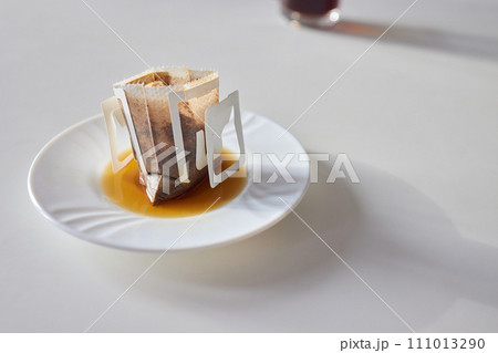 brewing process,a bag filled with boiling water for drip coffee in a cup,top view. 111013290