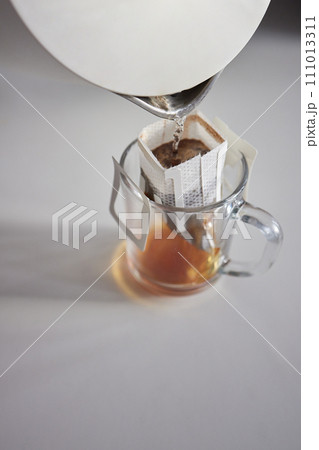 brewing process,a bag filled with boiling water for drip coffee in a cup,top view. 111013311