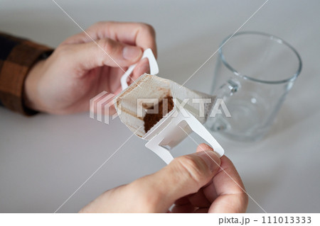brewing process,a bag filled with boiling water for drip coffee in a cup,top view. 111013333