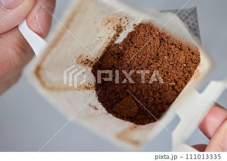 brewing process,a bag filled with boiling water for drip coffee in a cup,top view. 111013335