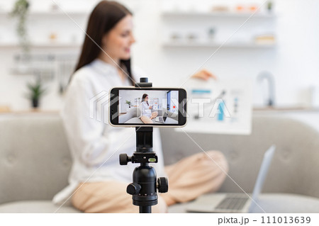 Young caucasian brunette financier woman filming herself on cell phone. 111013639