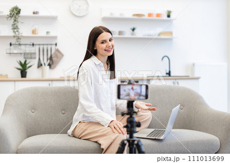 Cheerful content maker recording video to followers on modern smartphone. 111013699