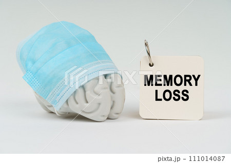 On a white surface next to the brain there is a notepad with the inscription - MEMORY LOSS On a white surface next to the brain there is a notepad with the inscription - MEMORY LOSS 111014087