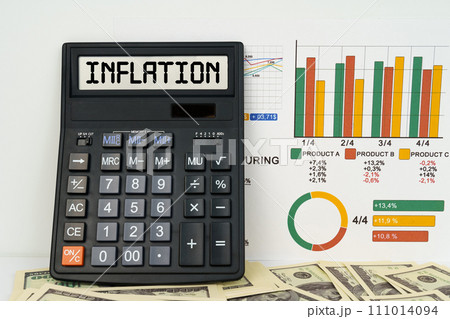 On the table are financial reports, dollars and a calculator with the inscription - Inflation 111014094