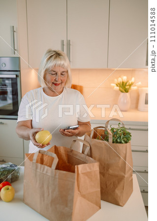 Portrait of woman unpacking paper box with food while enjoying delivery from farmers market, copy space 111014588