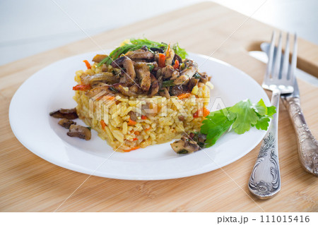 Diet pilaf with mushrooms and vegetables in a plate . 111015416