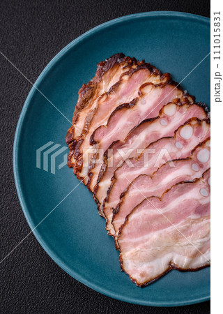 Delicious fresh pancetta or bacon with salt and spices cut into thin slices Delicious fresh pancetta or bacon with salt and spices cut into thin slices 111015831