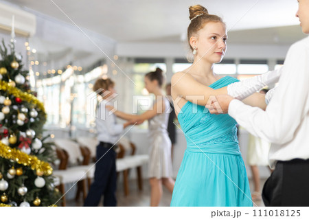 Smiling teenage girl enjoying slow dance with friend at Christmas party Smiling teenage girl enjoying slow dance with friend at Christmas party 111018125