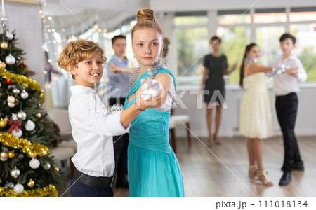 Enthusiastic adolescent dancers practicing partner dance in Christmas studio 111018134