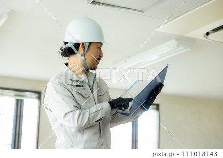 天井を点検する作業着の男性　 111018143