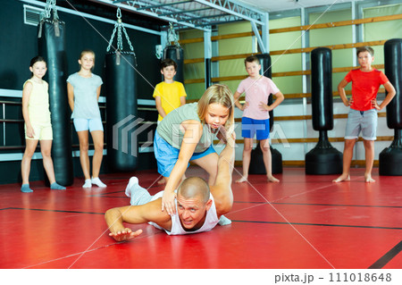 Children practice self-defense techniques on coach 111018648