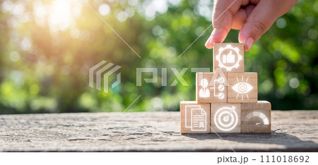 Best practice concept, Hand holding wooden block on desk with best practice icon on virtual screen. Target, Knowledge, Vision, Potential, Strategy, Business Process, Skill, Result. 111018692