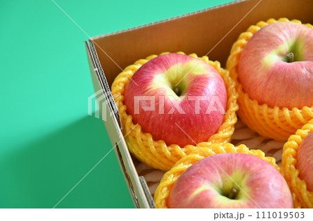beautiful pink apple in the box on green background, healthy fruit 111019503