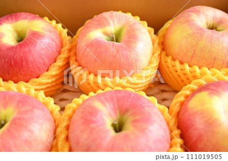 beautiful pink apple in yellow wrap bubble, healthy fruit in the box 111019505