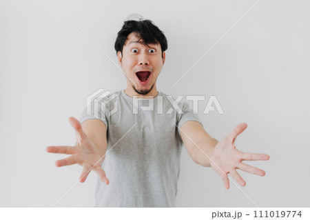 Asian man in grey t-shirt do funny surprised face isolated on white. Asian man in grey t-shirt do funny surprised face isolated on white. 111019774
