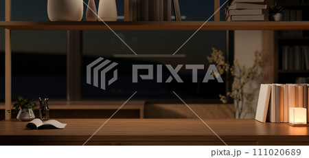 Cosy home office at night with a copy space on a wooden table and dim light from a table lamp. 111020689