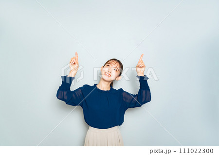 コピースペースを両手で指さす女性 111022300