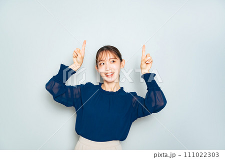 上を両手で指さす女性 111022303