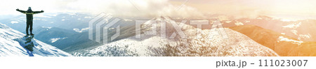 Silhouette of alone tourist standing on snowy mountain top in winner pose with raised hands enjoying view and achievement on bright sunny winter day. Adventure, outdoors activities, healthy lifestyle. Silhouette of alone tourist standing on snowy mountain top in winner pose with raised hands enjoying view and achievement on bright sunny winter day. Adventure, outdoors activities, healthy lifestyle. 111023007